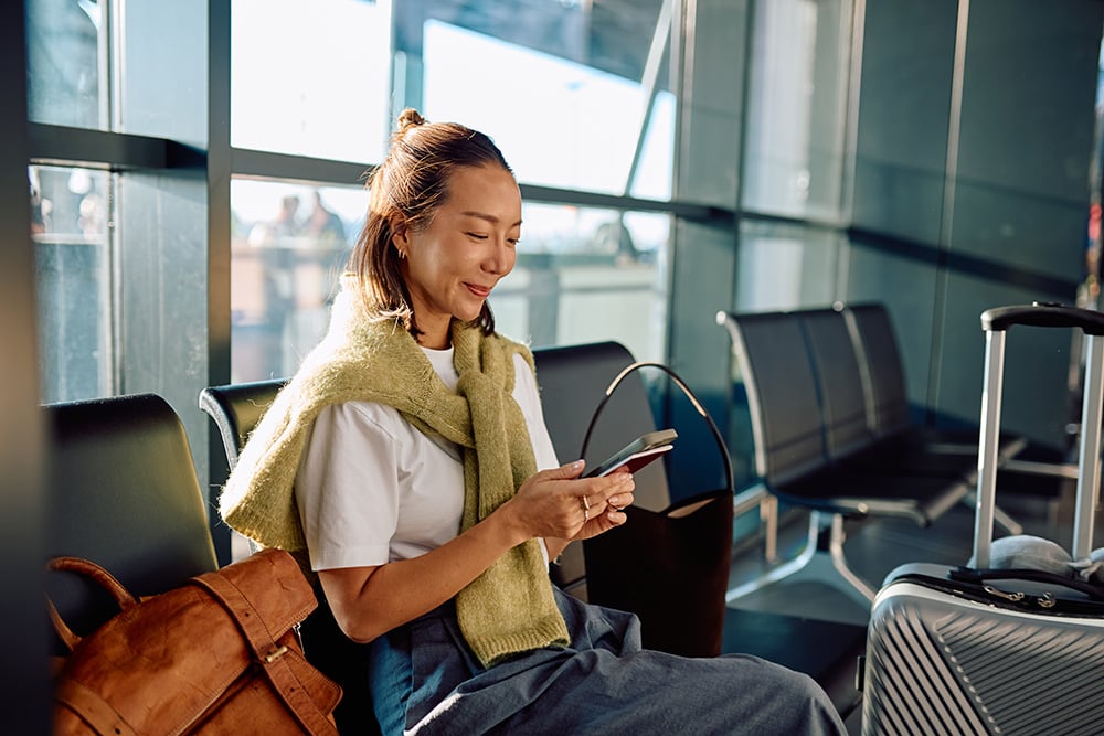 Frau mit Gepäck wartet entspannt im Abflugbereich – Symbolbild für komfortables Reisen über Frankfurt Airport