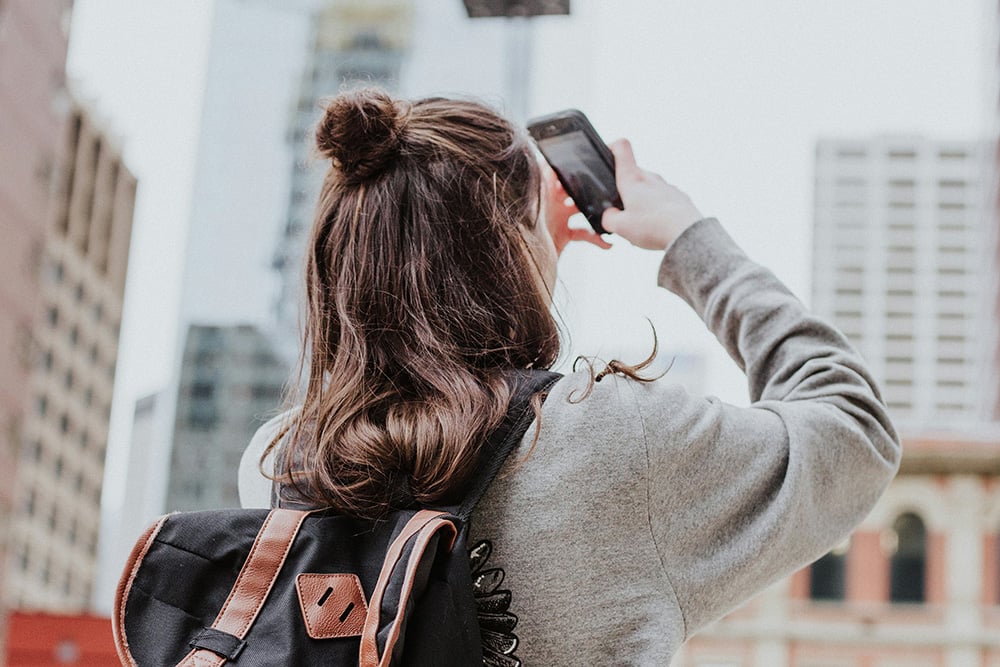 Reisende fotografiert die Frankfurter Skyline – Symbolbild für Aufenthalt und Übernachtung nahe Frankfurt Airport